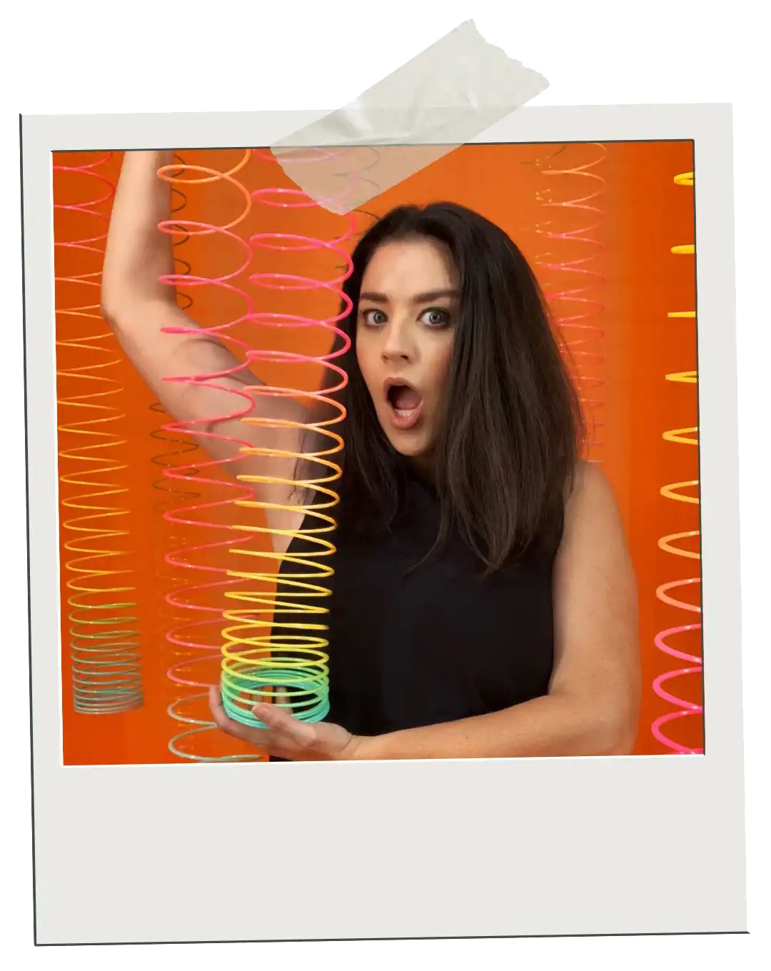 Killer Courses polaroid of Jordan holding a colorful slinky in front of a bright orange background