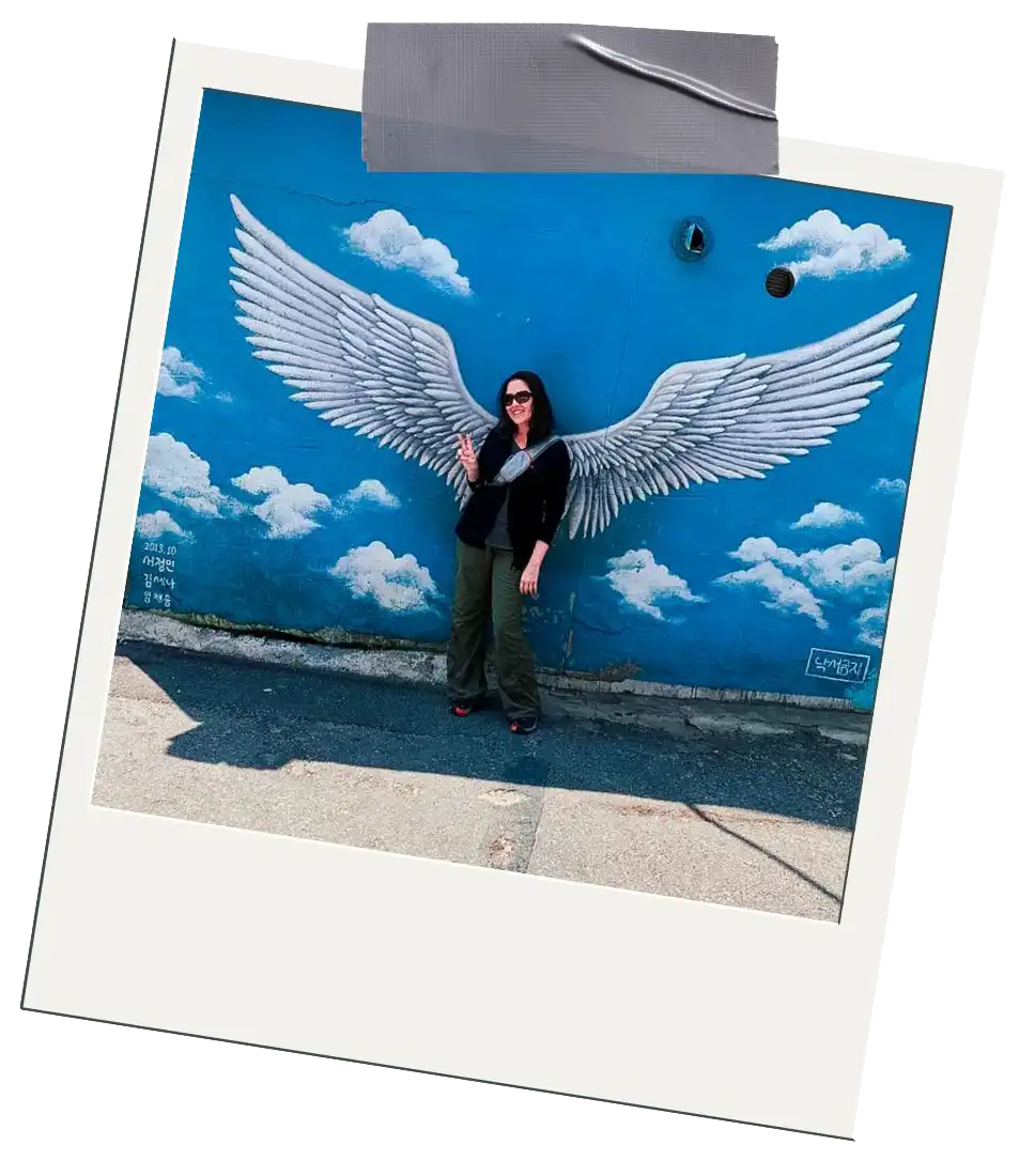 Places Global Debauchery Has Been Polaroid of Jordan standing in front of a wings and blue sky mural