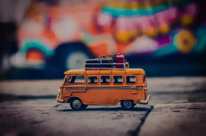 Toy bus on stone sidewalk with street art in background